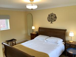 a bedroom with a bed with a tree on the wall at Peaceful house ideal for dogs lovely location in Aldeburgh
