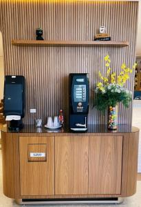 a reception desk with a phone and flowers on it at Caxias Thermas Hotel in Piratuba