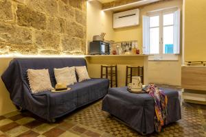 a living room with a couch and a kitchen at Monolocale Alguer in Alghero +18 photos
