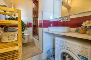 a laundry room with a sink and a washing machine at Monolocale Alguer in Alghero