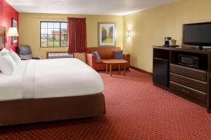 a hotel room with a bed and a flat screen tv at Baymont by Wyndham Cedar Rapids in Cedar Rapids +38 photos