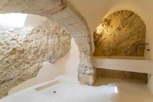 a bathroom with a stone wall and a bath tub at Paleopoli Cave House in Kythira