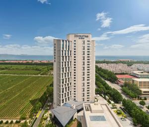 an aerial view of a tall white building at Doubletree By Hilton Yantai Golden Coast Hotel & Suites in Yantai