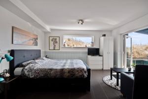 a bedroom with a bed and a large window at Co's Duyne - Beautiful studio near the dunes of Callantsoog in Callantsoog