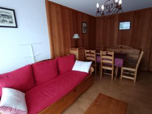un salon avec un canapé rouge et une table dans l'établissement Appartement cosy à 30m des pistes, plein sud avec terrasse - FR-1-445-145, à Montgenèvre 8 autres photos