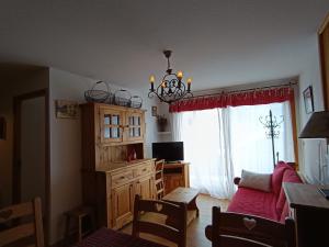 un salon avec un canapé et une fenêtre dans l'établissement Appartement cosy à 30m des pistes, plein sud avec terrasse - FR-1-445-145, à Montgenèvre