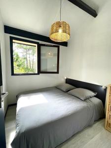 een slaapkamer met een bed met twee kussens en een raam bij Lou Hapchot in Lacanau