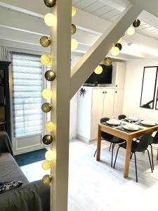 een woonkamer met een eettafel en een trap bij Lou Hapchot in Lacanau +11 foto's