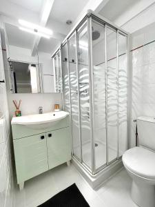 een badkamer met douche, wastafel en toilet bij Lou Hapchot in Lacanau