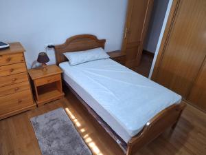 a bedroom with a bed with a dresser and a night stand at Apartamento Pose Arteixo in Arteixo
