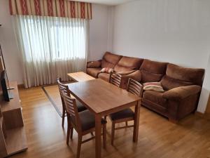 a living room with a couch and a table and chairs at Apartamento Pose Arteixo in Arteixo