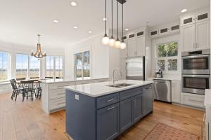 a large kitchen with white cabinets and a kitchen island at Sunset Peak - 1928 Ocean Road in Saint Simons Island