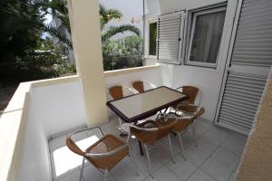 a table and chairs on the balcony of a house at Apartments Memidz in Budva