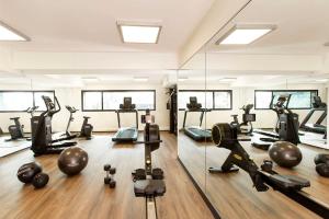 a gym with treadmills and pilates equipment and mirrors at Hilton Lille in Lille
