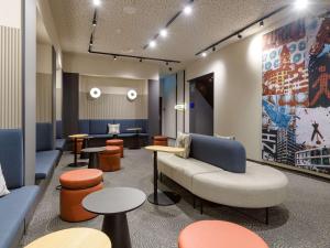una sala d'attesa con divano, sedie e tavoli di Mercure Zürich City a Zurigo