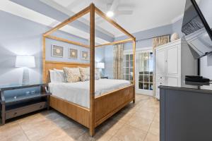 a bedroom with a canopy bed and a television at The Oasis at Orange Beach 2206 (Phoenix West II) in Orange Beach +108 photos