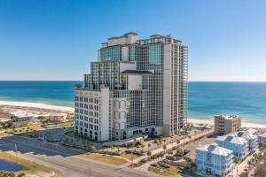 an aerial view of a tall building next to the ocean at The Oasis at Orange Beach 2206 (Phoenix West II) in Orange Beach