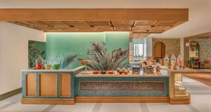 a kitchen with a bar with a painting on the wall at La Festa Phu Quoc, Curio Collection By Hilton in Phu Quoc