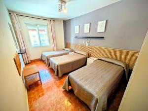 a hotel room with two beds and a sink at Hostal Jentoft in Seville