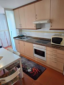 a kitchen with a sink and a stove top oven at Apartamento Pose Arteixo in Arteixo +10 photos