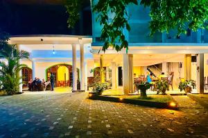a building with people sitting in a courtyard at night at Gamagedara Resort in Dambulla