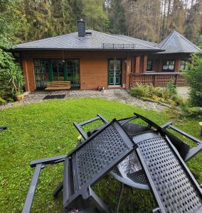 a house with a grill in front of a yard at Falkenstein Hütten Haus Waldluft in Bad Schandau