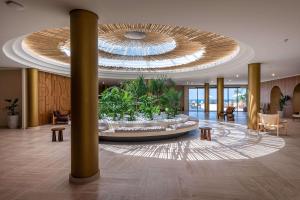 a lobby with a large fountain in the middle of a building at Isla Brown Chania Resort, Curio Collection by Hilton in Stavros