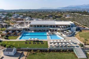 an aerial view of a resort with a swimming pool at Isla Brown Chania Resort, Curio Collection by Hilton in Stavros