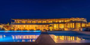 a large building with a swimming pool at night at Isla Brown Chania Resort, Curio Collection by Hilton in Stavros