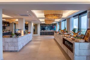 a lobby of a hotel with a buffet line at Isla Brown Chania Resort, Curio Collection by Hilton in Stavros