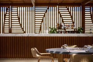 a table and chairs in a restaurant with wooden walls at Isla Brown Chania Resort, Curio Collection by Hilton in Stavros