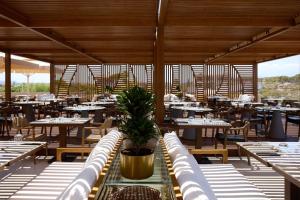 a dining room with tables and chairs and tablesearcher at Isla Brown Chania Resort, Curio Collection by Hilton in Stavros