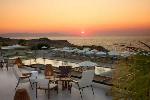 a sunset over a pool at a resort at Isla Brown Chania Resort, Curio Collection by Hilton in Stavros
