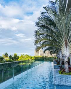 ホノルルにあるKa Laʻi Waikiki Beach, LXR Hotels & Resortsのヤシの木が並ぶプール
