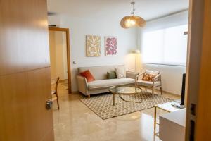 uma sala de estar com um sofá e uma mesa em Teatro Suites Málaga CITY FLAT em Málaga