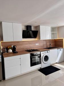 a white kitchen with a stove and a washing machine at Maison Design in Langres +20 photos