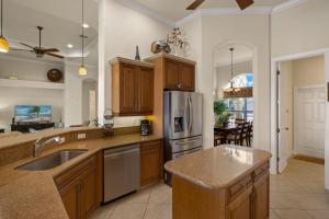 a kitchen with wooden cabinets and a stainless steel refrigerator at Villa Somada in Cape Coral
