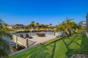 a deck with tables and chairs next to a body of water at Villa Somada in Cape Coral