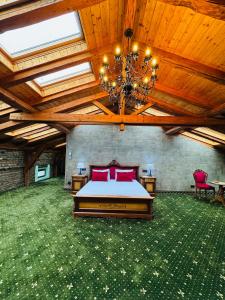 ein Schlafzimmer mit einem Bett und einer Decke mit einem Kronleuchter in der Unterkunft JMR Splendor - Private Sauna & Bathtub Suites in Constanţa