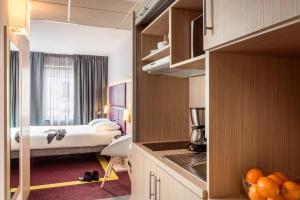 a hotel room with a bed and a room at Aparthotel Adagio Paris Malakoff Chatillon in Malakoff