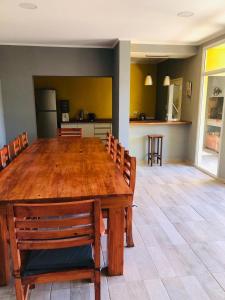 a dining room with a large wooden table and chairs at La quinta de los peques in Los Toldos