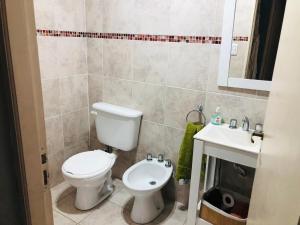 a bathroom with a toilet and a sink at La quinta de los peques in Los Toldos