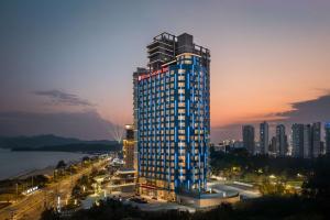 a tall building with lights on top of it at Hilton Garden Inn Shanwei Haibin Boulevard in Shanwei