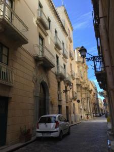 a white car parked on a street next to buildings at Scabi Apartments in Trapani