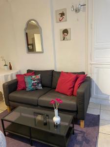 a living room with a brown couch with red pillows at Parvis de la cathédrale de Bayeux vue directe in Bayeux