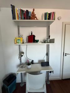 a desk with a chair and shelves with books at Shoreditch Rooftop Suites in London