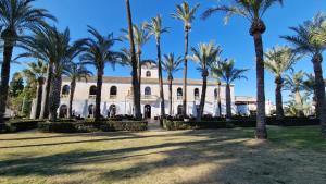 a building with palm trees in front of it at Lovely Ground Floor 2 Bed with Golf Course Views in Sucina