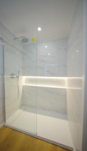 a shower with a glass door in a bathroom at Front Beach Costa Caparica Lisbon in Costa da Caparica +30 photos