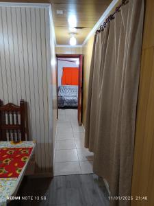 un pasillo con una habitación con cama y cortina en Casa en arriendo, en Quintero