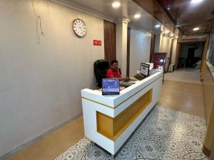 a young boy sitting at a counter in a lobby at Vibha Raj Grand in Kānpur